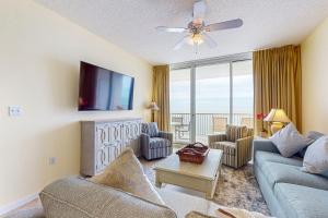 a living room with a couch and a tv at The Beach Club 1102B in Gulf Highlands