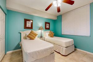 two beds in a bedroom with blue walls at The Beach Club 1102B in Gulf Highlands +46 photos