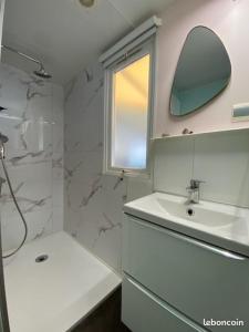 a white bathroom with a sink and a mirror at mobil home de luxe in Le Pradet