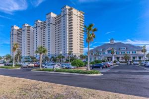 a large apartment building with cars parked in a parking lot at The Beach Club 1102B in Gulf Highlands