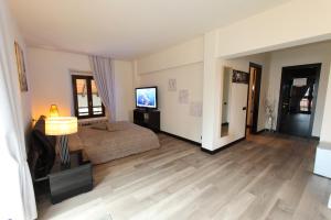 a bedroom with a bed and a flat screen tv at Il Castello B&B in Varallo Pombia