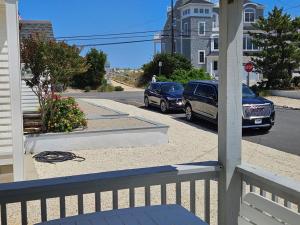 dos autos estacionados en un estacionamiento en una calle en Brant Beach - Lovely, 1St Floor Duplex, Only 3 Houses From The Beach No Smoking, And No Pets Permitted Property Now Has Electronic Locks - Tenant, en Brant Beach
