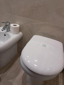 a bathroom with a white toilet and a sink at La Petite Maison in Naples