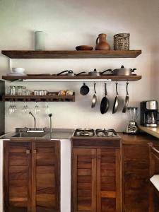 a kitchen with wooden cabinets and a sink and utensils at Cabañas Uma 2 in San Agustinillo +48 photos