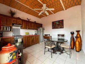 a kitchen with a table and chairs and a ceiling fan at Hermi Bungalows in La Peñita de Jaltemba