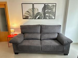 a gray couch in a living room with a table at Apartamentos Vernia 3-9 in Xàtiva