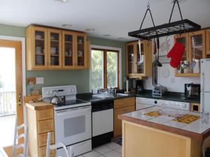 eine Küche mit Holzschränken und weißen Geräten in der Unterkunft Duplex 2Nd Fl Beach Badges Oceanside Outdoor Shower Wifi in Brant Beach