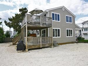 a house with a large deck on a beach at Duplex 1St Fl Ocean Side Beach Badges Outdoor Shower Wifi 40794 in Brant Beach