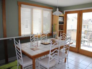 ein Esszimmer mit einem Tisch und weißen Stühlen in der Unterkunft Duplex 2Nd Fl Beach Badges Oceanside Outdoor Shower Wifi in Brant Beach + 15 Fotos