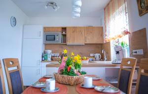 eine Küche mit einem Tisch, auf dem ein Blumenkorb steht in der Unterkunft Ferienwohnung Nähe Legoland Günzburg 86 qm mit Balkon in Burtenbach