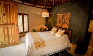 a bedroom with a large bed in a room at The Yellow Nest Tulum in Tulum