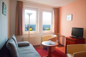 a living room with a couch and a television at Pension Ostseeblick in Sassnitz