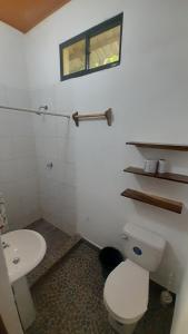 a bathroom with a white toilet and a sink at Rancho de Pedro in El Viejo +55 photos