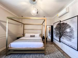 a bedroom with a canopy bed and two pictures on the wall at Hotel Mansion E Borbon in León +86 photos