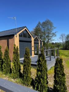 a wooden house with a porch and trees at Plaża Patelnia in Nowe Rumunki