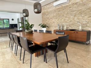 a dining room with a wooden table and chairs at Villa paraíso in Juan Dolio