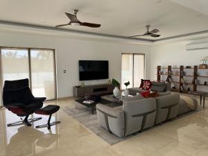 a living room with a couch and a tv at Villa paraíso in Juan Dolio