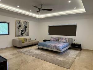 a living room with a bed and a flat screen tv at Villa paraíso in Juan Dolio +58 photos