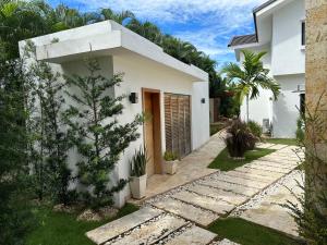 a white house with a pathway in front of it at Villa paraíso in Juan Dolio