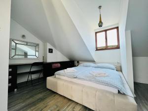 a bedroom with a bed and a mirror at Apartament Metamorfoza in Nowy Targ