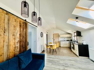 a living room with a blue couch and a kitchen at Apartament Metamorfoza in Nowy Targ