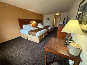 a hotel room with two beds and a table at Richland Inn and Suites in Sidney