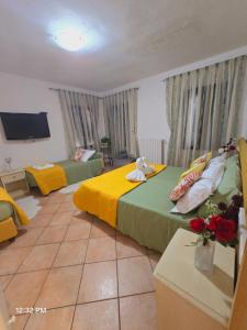 a bedroom with two beds with yellow and green sheets at Appartamento Cleo in Campalto