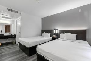 Una habitación de hotel con dos camas y un lavabo. en Motel 6-Oceanside, CA, en Oceanside