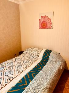 a bed in a room with a flower on the wall at grand appartement strasbourg in Eckbolsheim