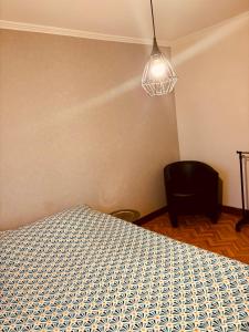 a bedroom with a bed and a lamp and a chair at grand appartement strasbourg in Eckbolsheim