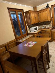 a kitchen with a wooden table and a microwave at grand appartement strasbourg in Eckbolsheim