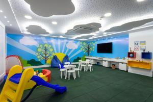 a room with a playroom with a tv and chairs at Apart Moderno Proximo ao Mar in Vila Velha