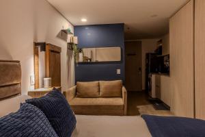 ein Wohnzimmer mit einer Couch und einem Sessel in einem Zimmer in der Unterkunft Apartasuite Smart cerca de la Fundación Santa Fé in Bogotá