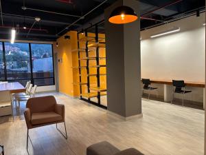 ein Zimmer mit einem Stuhl und einem Tisch und einigen Stühlen in der Unterkunft Apartasuite Smart cerca de la Fundación Santa Fé in Bogotá