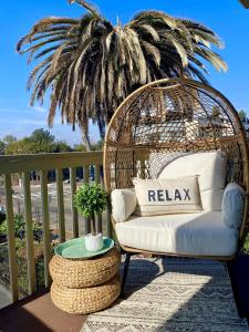 Una silla de ratán en un balcón con una palmera. en Bright & Quiet 1-Bed Condo with Balcony, en San Diego