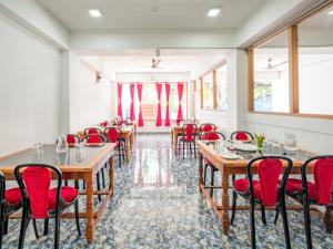 a dining room with tables and red chairs at ANIBESH HOTEL in Havelock Island