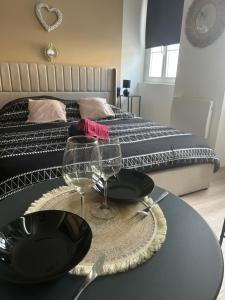 a table with glasses on top of it in front of a bed at La suite Tournonaise in Tournon-sur-Rhône