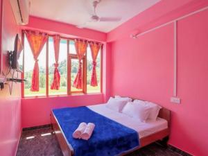 1 dormitorio con paredes rosas y 1 cama con chanclas en ANIBESH HOTEL, en Isla Havelock 23 fotos más