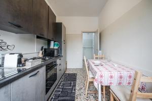 eine Küche mit Tisch und eine Küche mit Herd in der Unterkunft Smart Stay near Policlinico & City Center in Modena