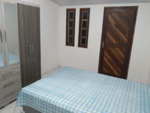 una camera da letto con un letto e una porta di legno di CASA AMARELA a Salvador