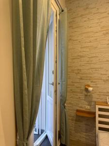 a shower with a curtain in a room with a window at Nonna Lisetta in Terzigno