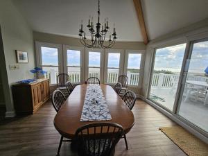 une salle à manger avec une table, des chaises et un lustre dans l'établissement Single Family, Wifi, Ship Bottom Oceanfront Home, Ocean Views, 14010, à Ship Bottom