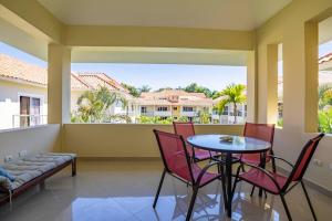 a balcony with a table and chairs and a large window at Pro Cab Paradise Condos Cabarete in Cabarete