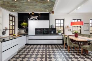 una cocina con armarios blancos y una mesa con un perro en la pared en Design Apartments - "Havelnest", en Schwielowsee 41 fotos más