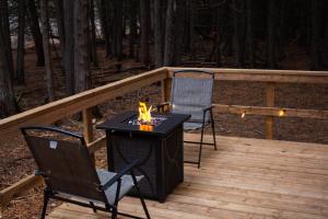 two chairs and a table on a wooden deck at The Bonne Chere at New Frontiers Retreat in Eganville