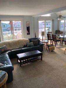 Una sala de estar con un sofá verde y una mesa. en Oceanside Beach Badges Wifi Ocean Views From The Decks! 5Th From The Beach Surf City 14016, en Surf City