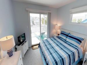 Un dormitorio con una cama y un televisor y un balcón. en Oceanside Beach Badges Wifi Ocean Views From The Decks! 5Th From The Beach Surf City 14016, en Surf City 18 fotos más