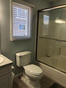 Un baño con inodoro y ducha de cristal. en Oceanside Beach Badges Wifi Ocean Views From The Decks! 5Th From The Beach Surf City 14016, en Surf City