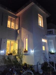 シャトノワにあるGîte avec parking, au calme, entre Colmar-Riquewihr et Obernai ,marchés de Noël, 3 chambres, avec terrasseの夜間の窓に灯る白い家