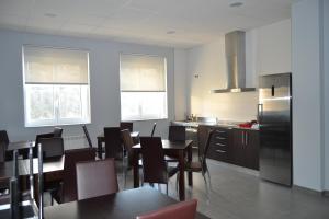 a kitchen with tables and chairs and a refrigerator at Pensión Lemos in Treacastela